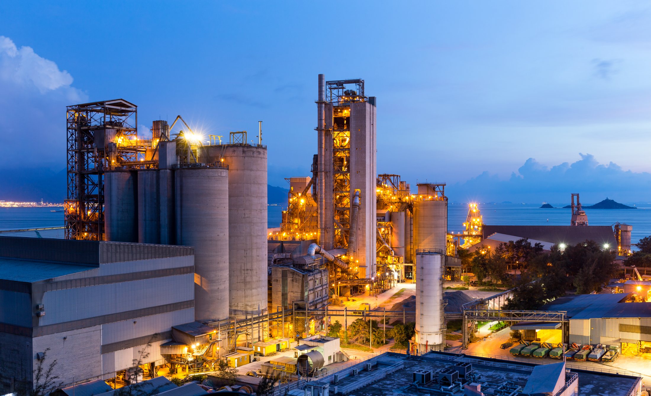 Cement plant at dusk, silos and towers picked out by floodlights